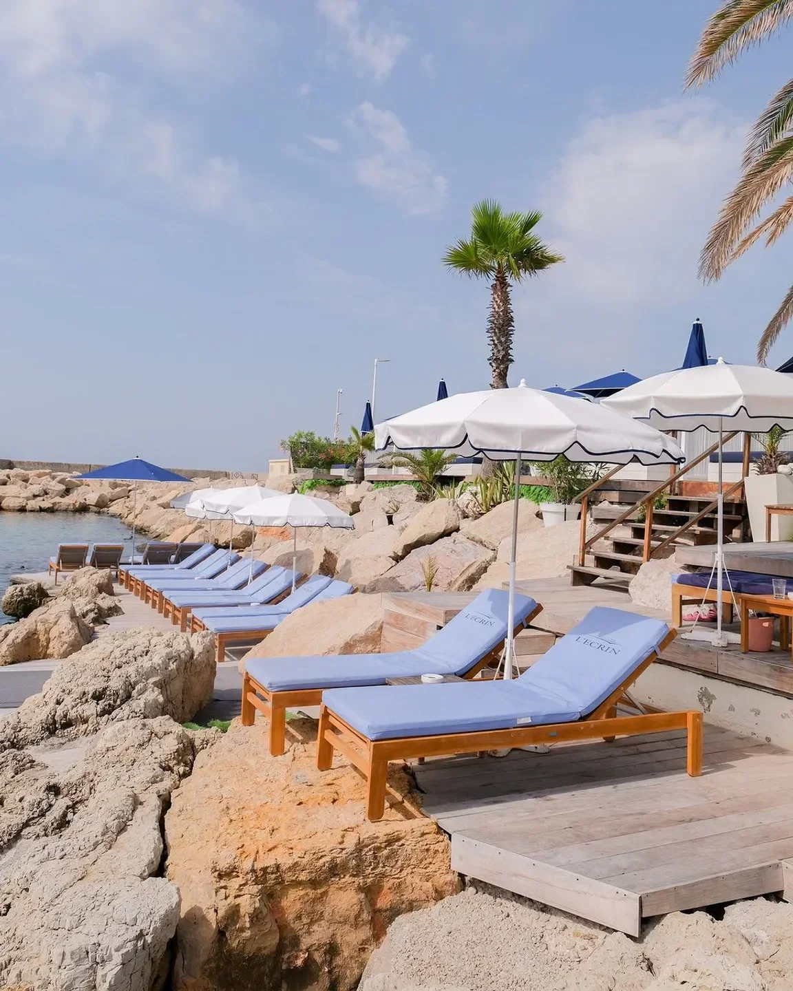 Beachfront seating at L'Écrin Plage in Cannes, with sun loungers and parasols