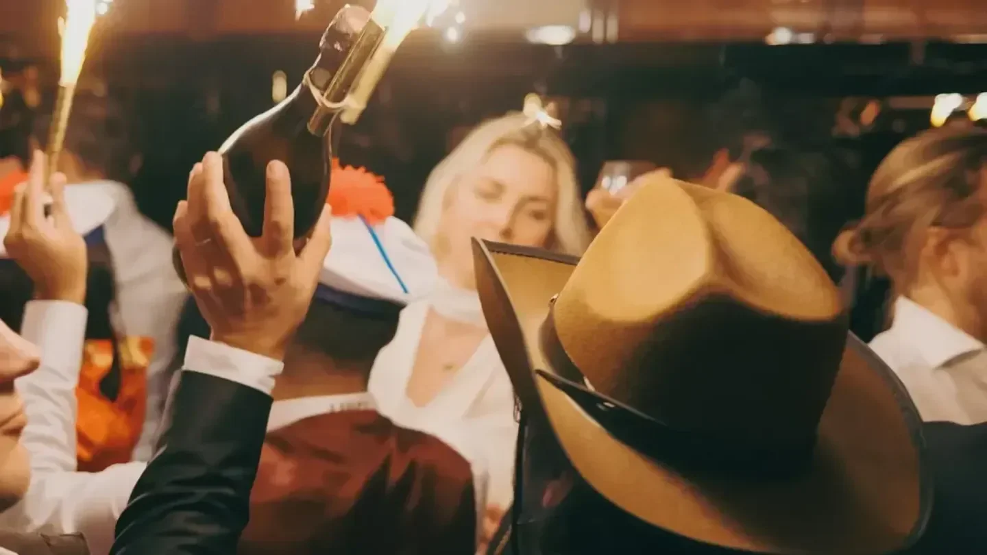 Celebrating at Luigi Cannes with champagne and sparklers amidst a lively crowd.