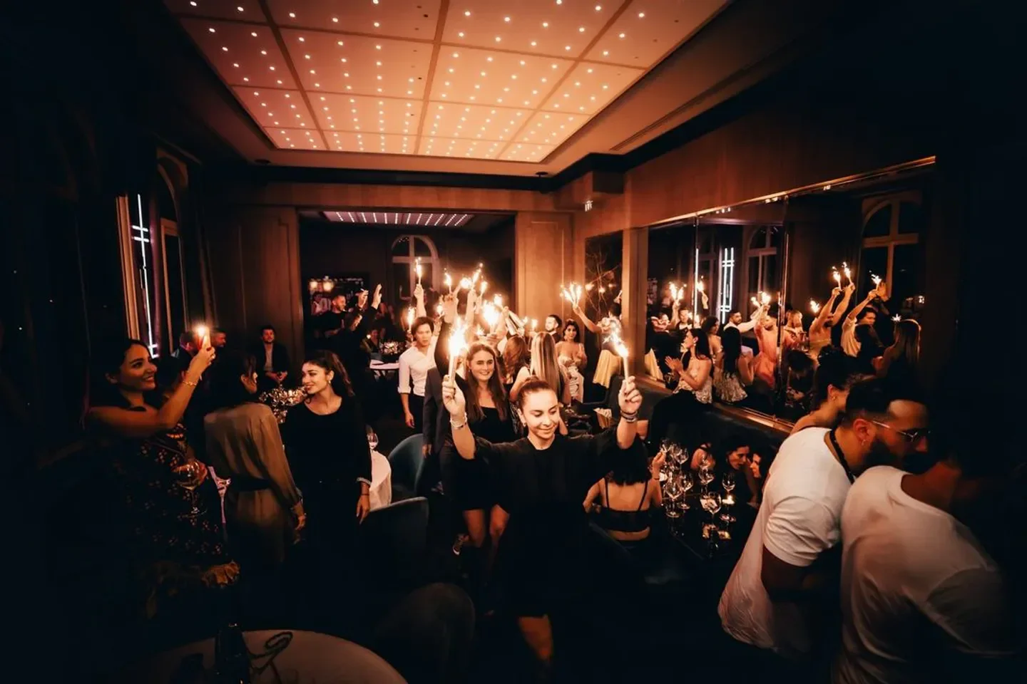 Victoria restaurant in Paris: Guests celebrating with sparklers in a lively atmosphere.